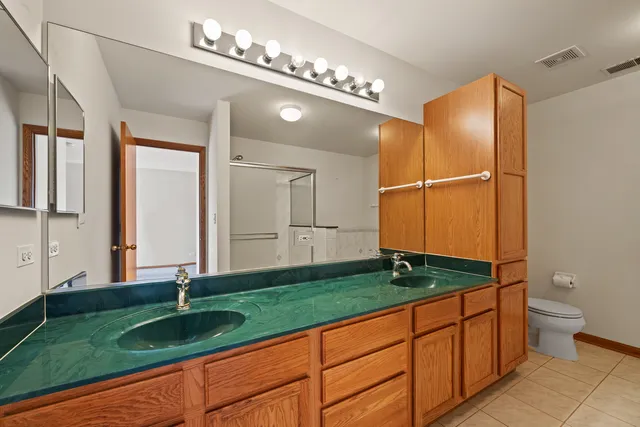 a bathroom with a granite countertop sink and a large mirror