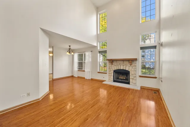 a view of a livingroom with wooden floor and a fireplace