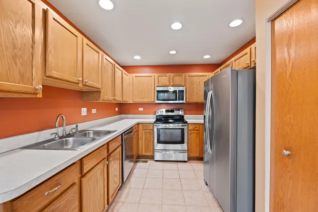 a kitchen with stainless steel appliances granite countertop a refrigerator and a sink