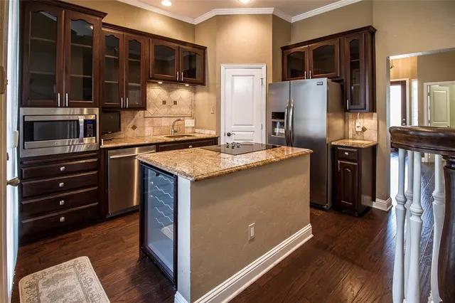 a kitchen with stainless steel appliances granite countertop a refrigerator and a stove