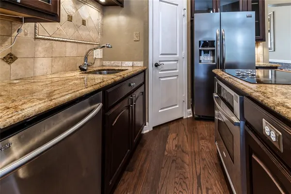 a kitchen with stainless steel appliances granite countertop a sink stove and refrigerator