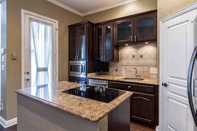 a kitchen with granite countertop a sink and cabinets