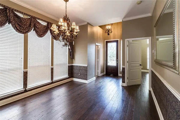 a view of a hallway with wooden floor and a kitchen