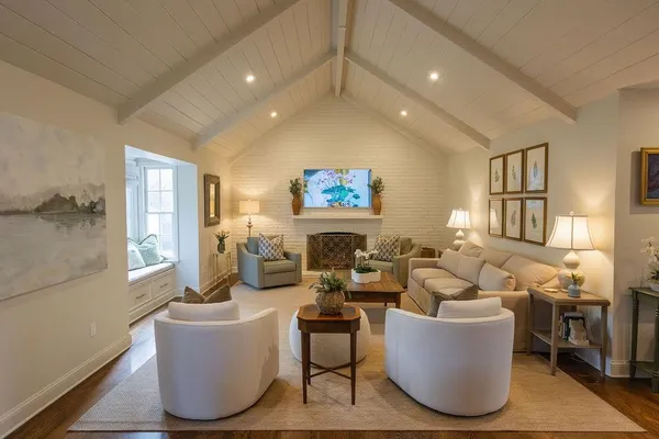 a living room with fireplace furniture and a large window