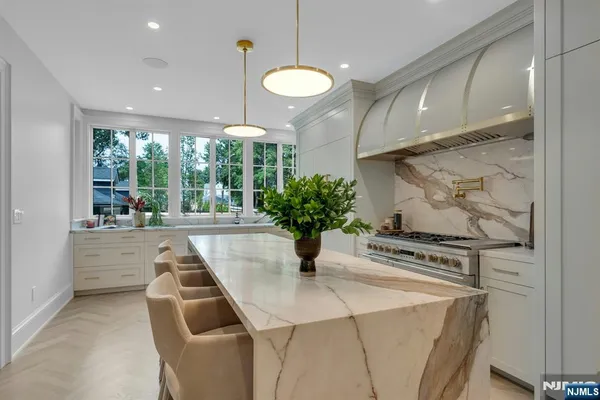 a kitchen with stainless steel appliances granite countertop a stove a refrigerator a oven a sink with a dining table and chairs