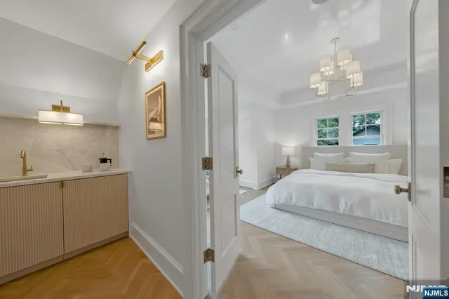 a bedroom with a large bed and a chandelier