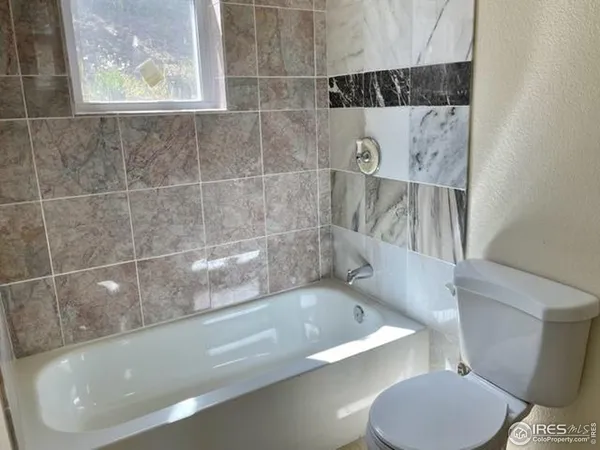 a bathroom with a tub and a toilet