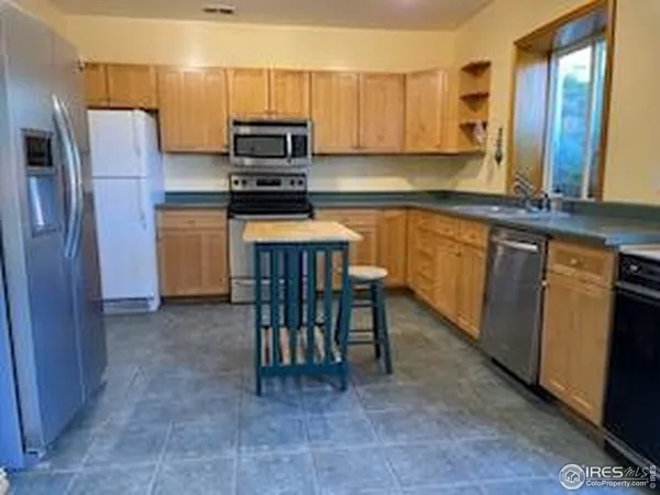 a kitchen with a refrigerator and a stove top oven
