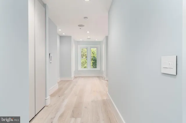 a view of a hallway with wooden floor and furniture