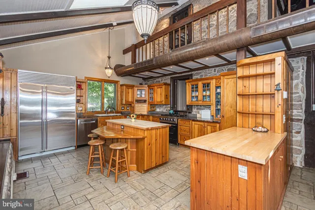 a kitchen with stainless steel appliances granite countertop a sink and a refrigerator