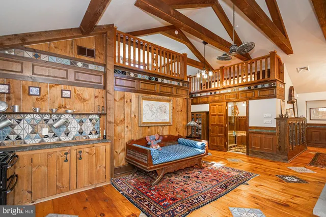 a living room with stainless steel appliances kitchen island granite countertop furniture a rug and a kitchen view