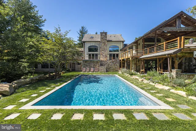 a view of a house with pool and sitting area