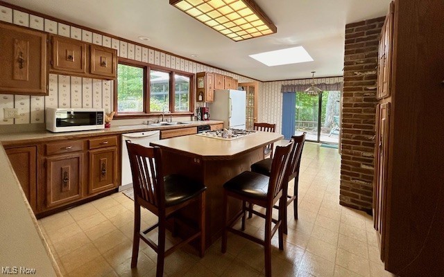 3422 Southern Road Richfield, OH 44286 - Photo 12 of 42 Kitchen with a breakfast bar, white appliances, pendant lighting, a center island, and a skylight