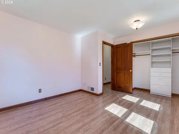 a view of an empty room with closet and a window