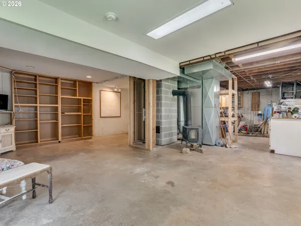 a view of an empty room with furniture and a window