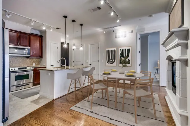 a living room with stainless steel appliances kitchen island granite countertop furniture a rug a fireplace and a counter top space