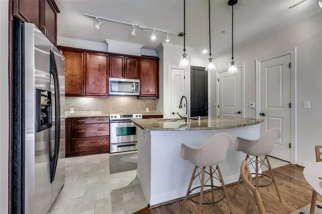 a kitchen with stainless steel appliances a stove a sink island and a refrigerator