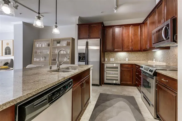 a kitchen with stainless steel appliances granite countertop a sink stove and refrigerator