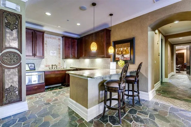 a kitchen with kitchen island granite countertop a stove a oven a dining table and chairs with wooden floor