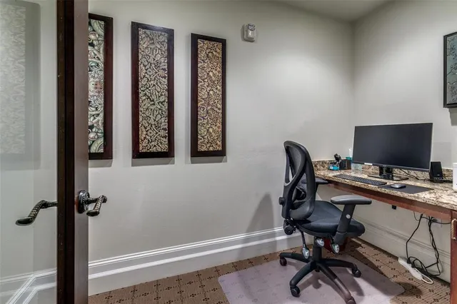 a view of a workspace with furniture and a window