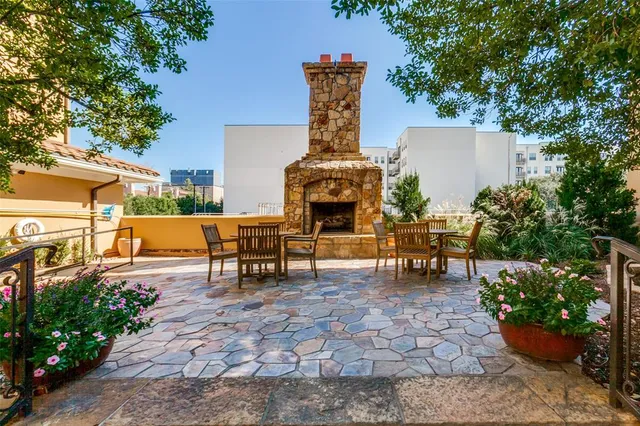 a view of a patio with table and chairs potted plants and large tree