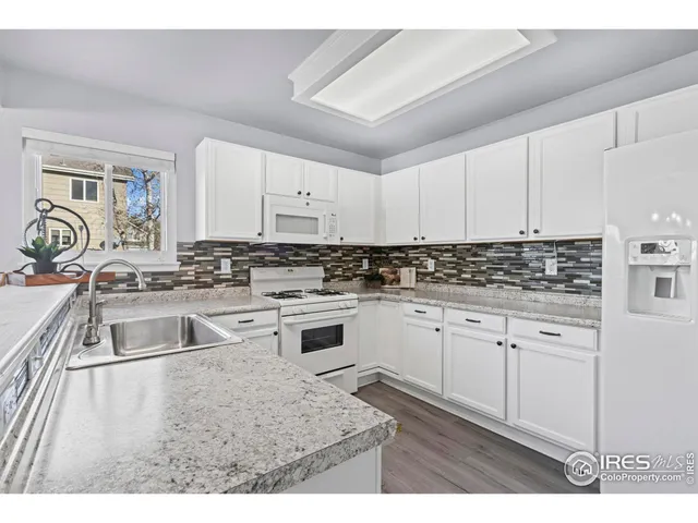 a kitchen with granite countertop a sink stove and cabinets