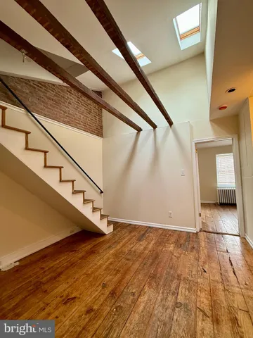 a view of a bedroom with wooden floor and a bed