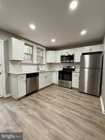 a kitchen with stainless steel appliances granite countertop a refrigerator stove a sink and dishwasher