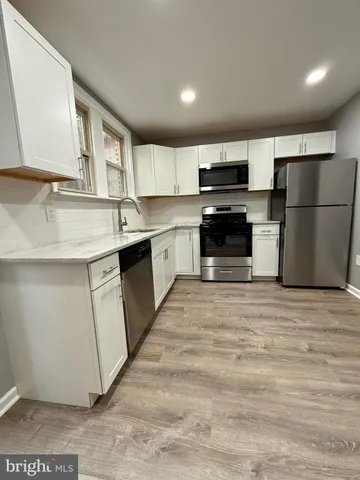 a kitchen with stainless steel appliances a stove a sink and a refrigerator