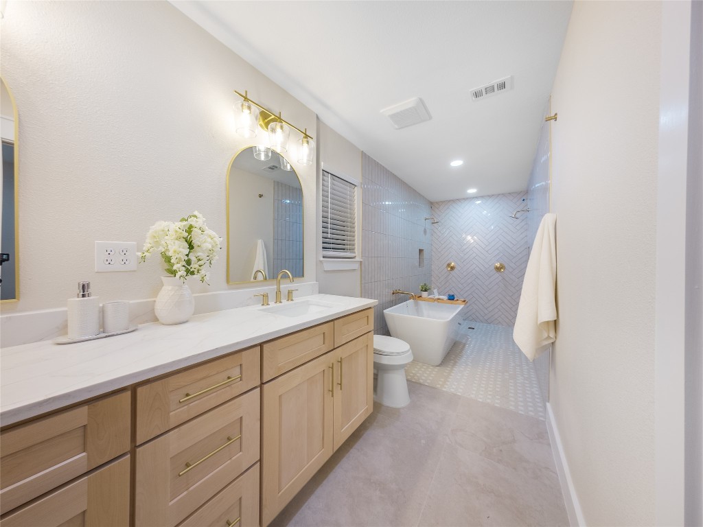 224 Clear Springs Road Georgetown, TX 78628 - Photo 19 of 32 Bathroom with a walk in shower, vanity, a freestanding bath, and tile walls