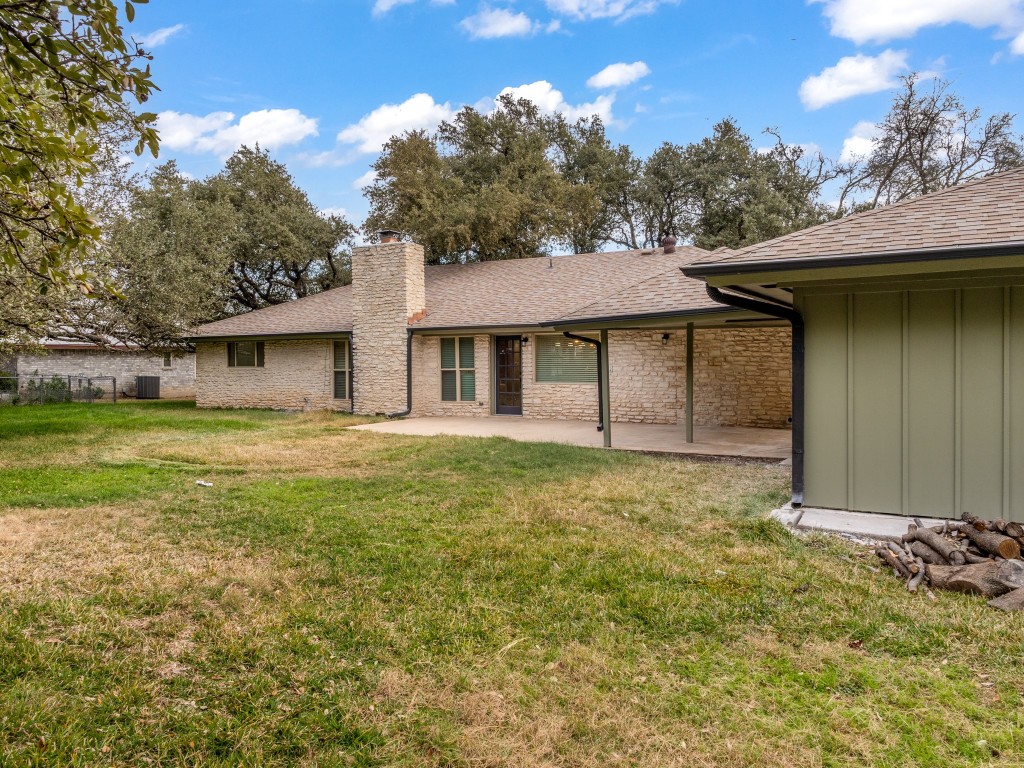 224 Clear Springs Road Georgetown, TX 78628 - Photo 29 of 32 Back of house featuring board and batten siding, a yard, a patio area, and roof with shingles