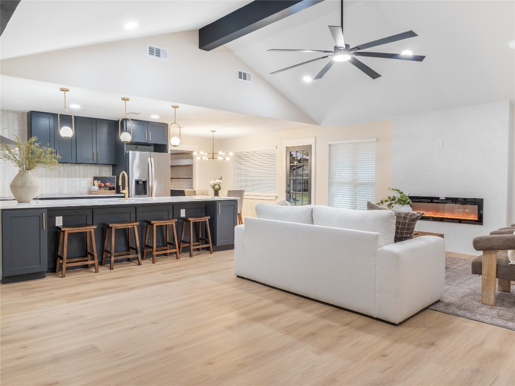 224 Clear Springs Road Georgetown, TX 78628 - Photo 9 of 32 Living area with high vaulted ceiling, recessed lighting, light wood finished floors, a glass covered fireplace, and beam ceiling