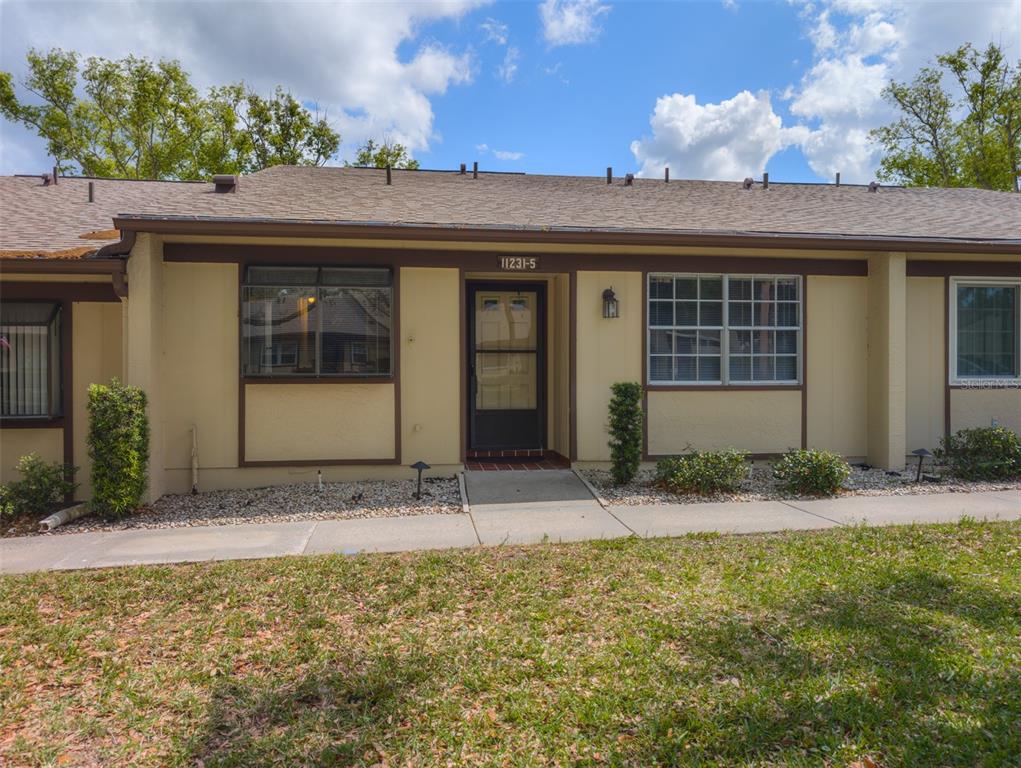 11231 Dollar Lake Drive, Unit 5 Port Richey, FL 34668 - Photo 1 of 1 a front view of a house with a porch