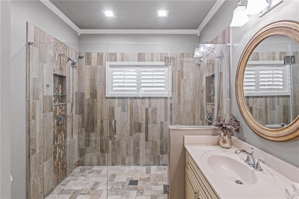 555 Douthit Ferry Road Cartersville, GA 30120 - Photo 22 of 36 a bathroom with a sink a mirror a shower and a window