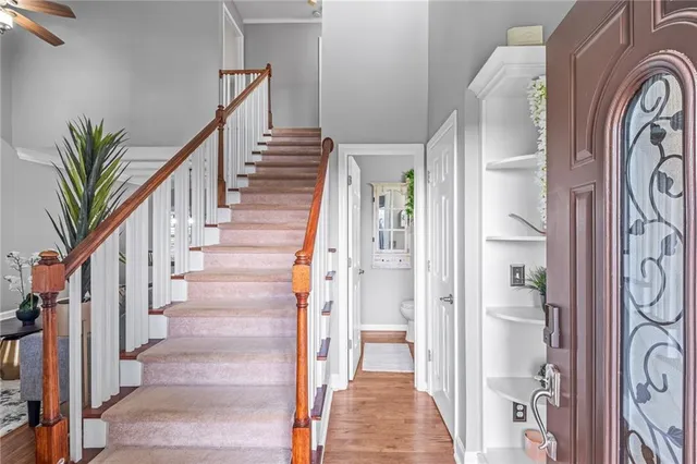 a view of a hallway with wooden floor and staircase