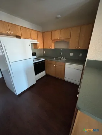 a kitchen with a refrigerator and a sink