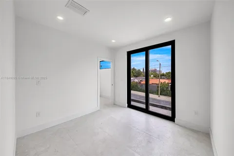 an empty room with sliding glass door and shower
