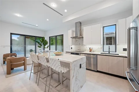 a large kitchen with stainless steel appliances a sink a stove and a refrigerator