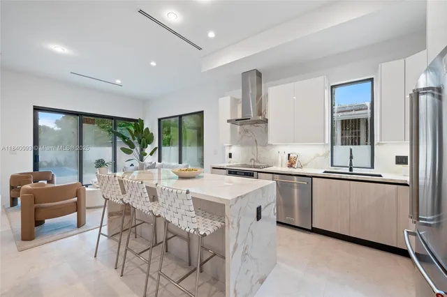 a large kitchen with stainless steel appliances a sink a stove and a refrigerator