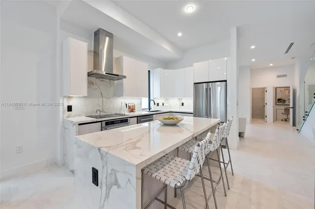 a kitchen with stainless steel appliances a sink and a refrigerator