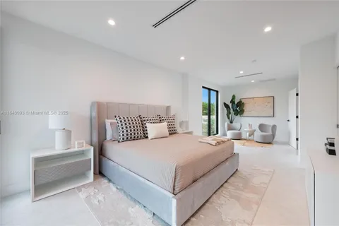 a spacious bedroom with a bed and glass wall