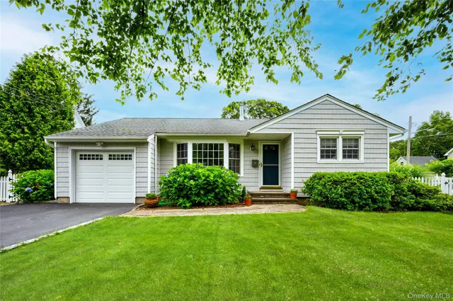 a front view of a house with a yard and green space