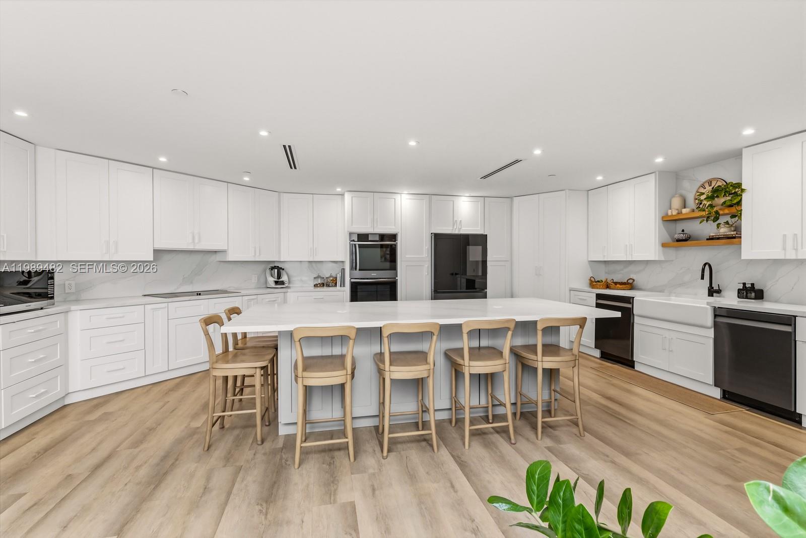 151 Crandon Boulevard, Unit 1222 Key Biscayne, FL 33149 - Photo 11 of 31 a kitchen with stainless steel appliances kitchen island granite countertop a table chairs sink and cabinets