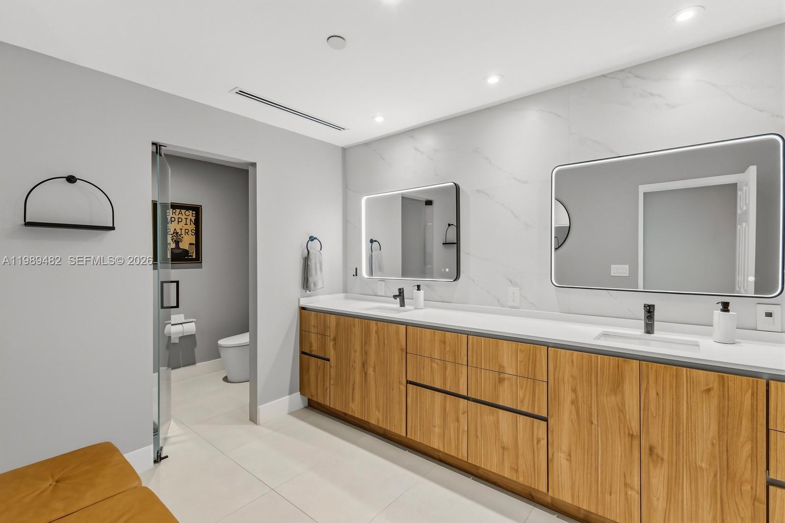 151 Crandon Boulevard, Unit 1222 Key Biscayne, FL 33149 - Photo 15 of 31 a spacious bathroom with a double vanity sink and a mirror