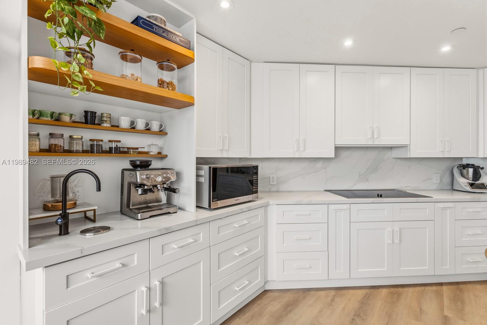 151 Crandon Boulevard, Unit 1222 Key Biscayne, FL 33149 - Photo 8 of 31 a kitchen with white cabinets and sink