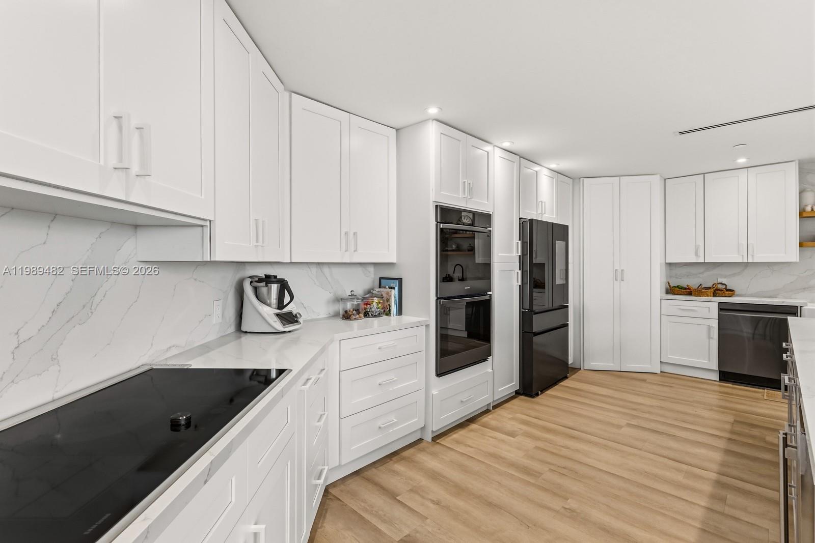 151 Crandon Boulevard, Unit 1222 Key Biscayne, FL 33149 - Photo 10 of 31 a kitchen with stainless steel appliances kitchen island granite countertop a refrigerator sink and white cabinets