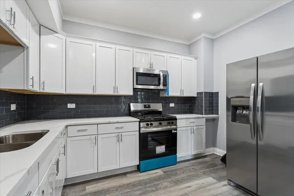a kitchen with cabinets stainless steel appliances and sink