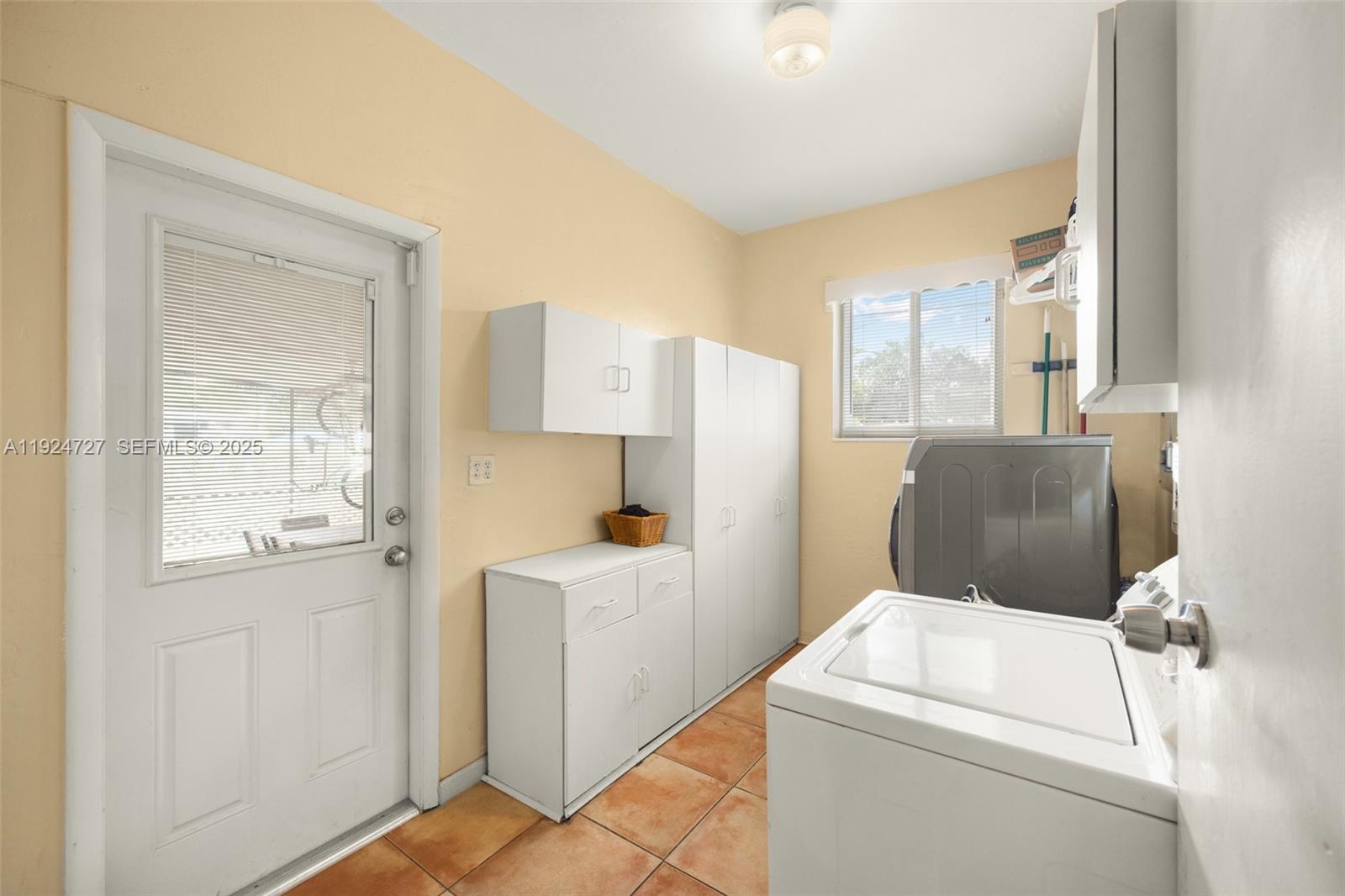 1420 Southwest 82nd Avenue Miami, FL 33144 - Photo 17 of 25 a view of washer and dryer with kitchen in the background