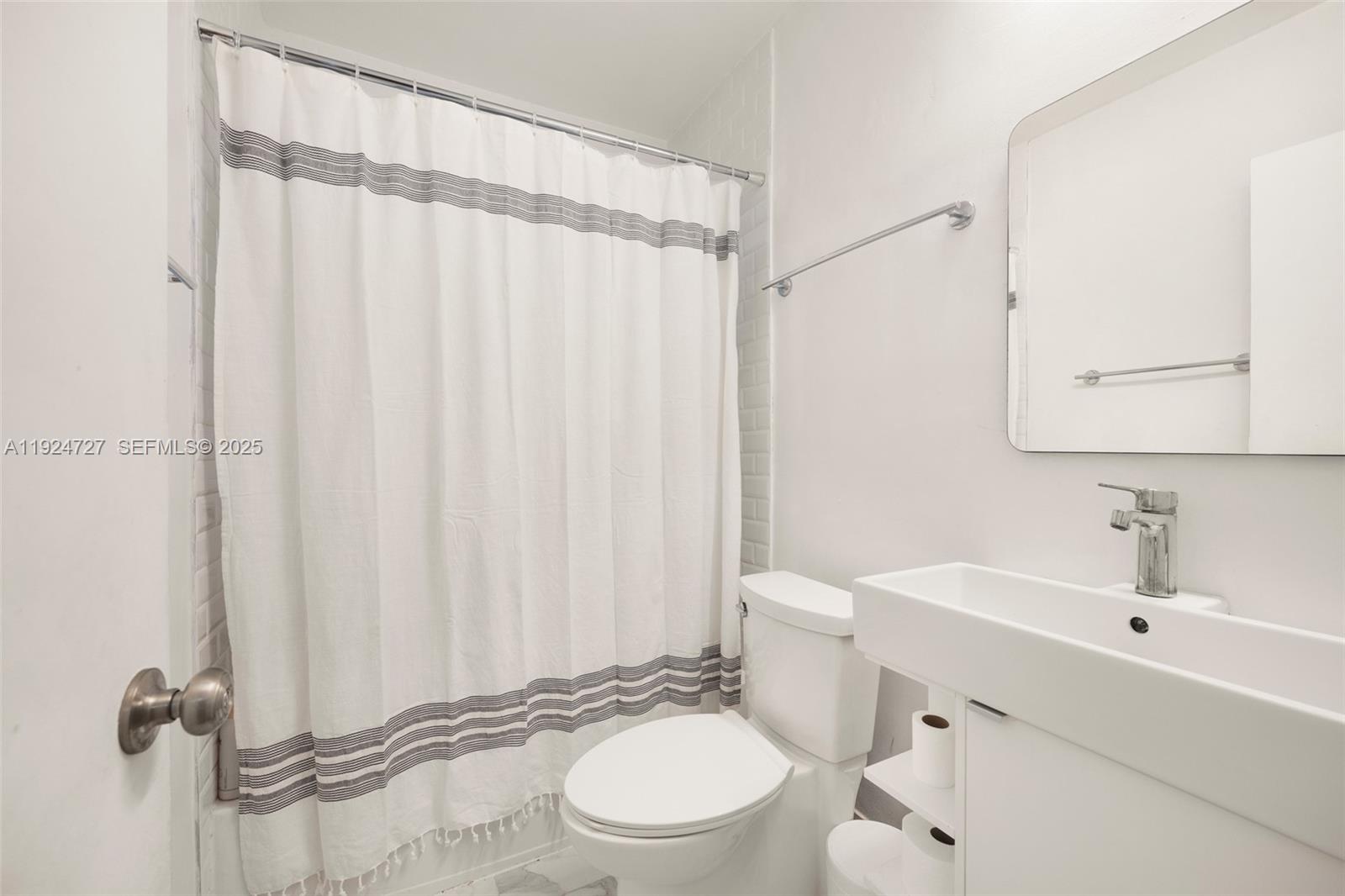 1420 Southwest 82nd Avenue Miami, FL 33144 - Photo 18 of 25 a bathroom with a sink a toilet and shower curtain