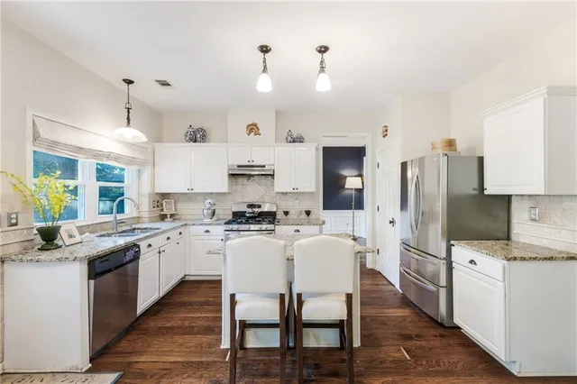 a kitchen with a center island wooden floor cabinets and a window